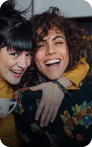 Two women hugging and smiling at the camera