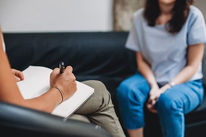 A therapist taking notes during a session