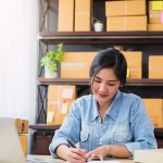 A woman sitting in an office writing at her desk