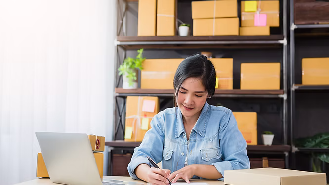 A woman sitting in an office writing at her desk