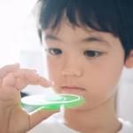 A young boy playing with a fidget spinner