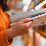 A hand flipping through a book in a library