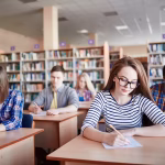 A group of students sitting an exam in a library