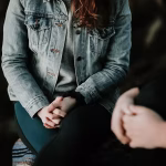 A woman sitting in a chair with her hands in her lap