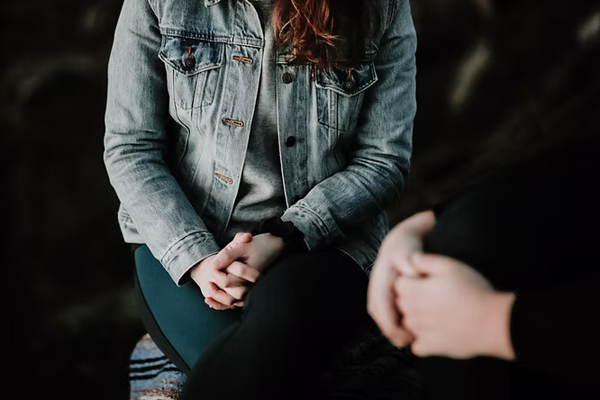 A woman sitting in a chair with her hands in her lap